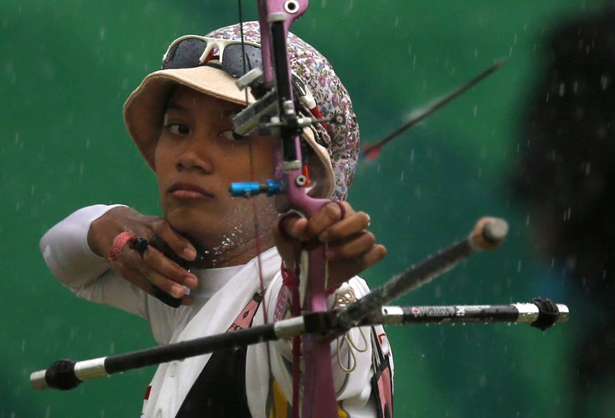 L’indonesiana Diananda Choirunisa, incurante della pioggia, cerca la mira e la massima concentrazione nel match contro la Cina ai Giochi asiatici (Reuters)